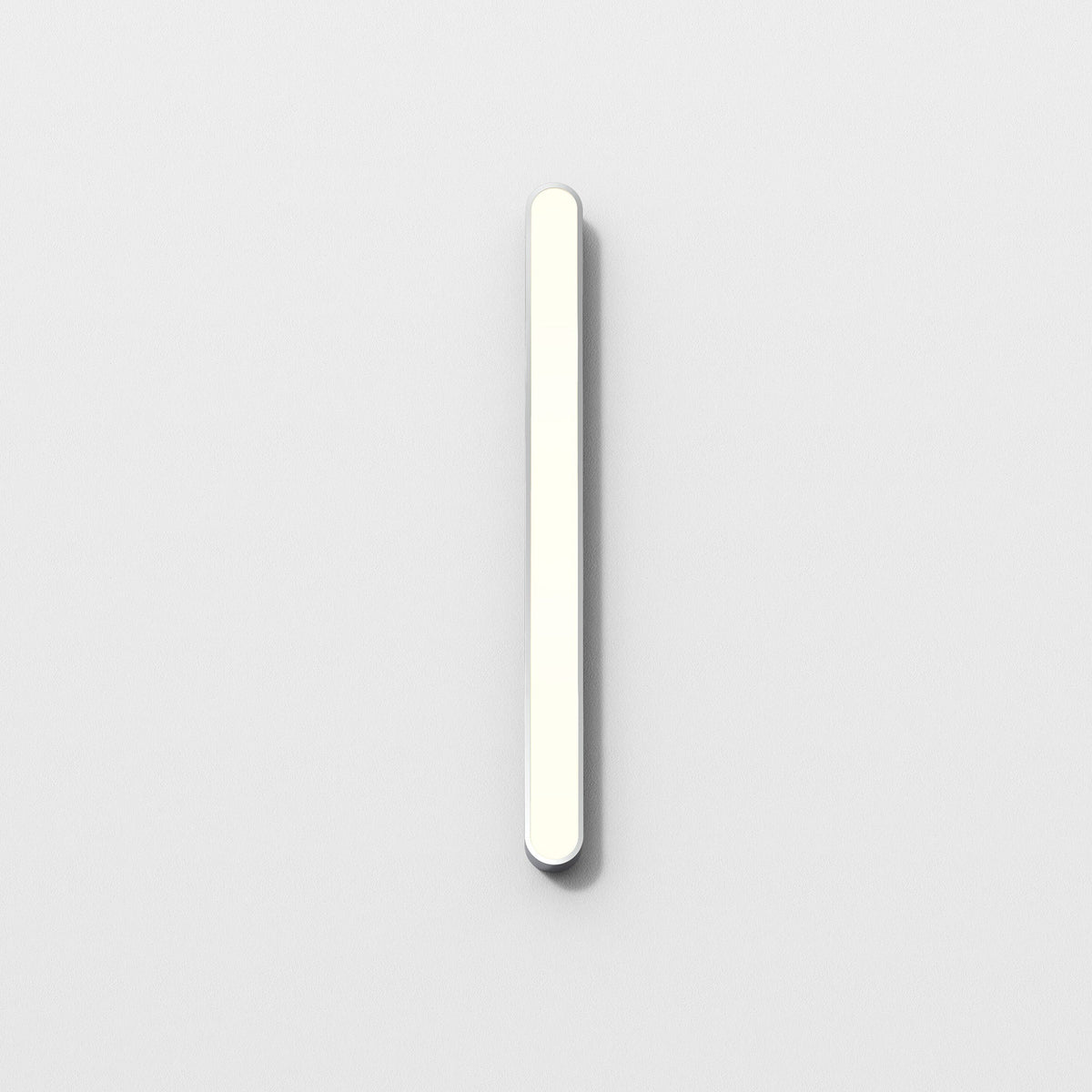 White rectangular LED light fixture with rounded ends, mounted vertically on a white wall
