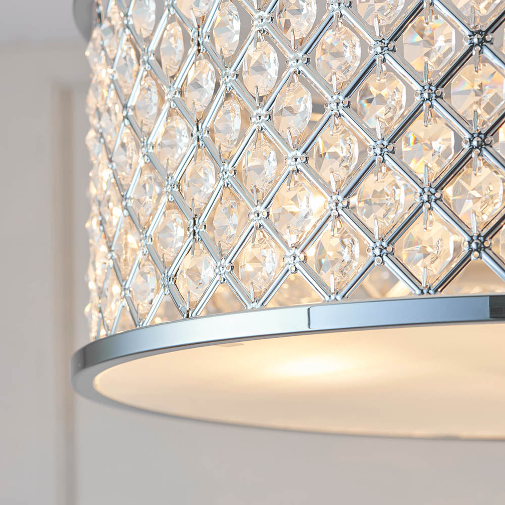 Close-up of the crystal-studded drum shade and chrome trim of a semi-flush ceiling light, illuminated.