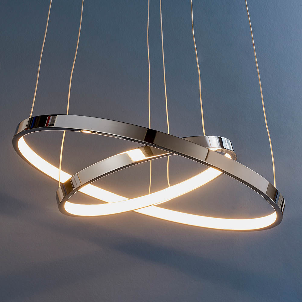 Close-up of a chrome LED pendant light featuring two intertwined rings with warm illumination.