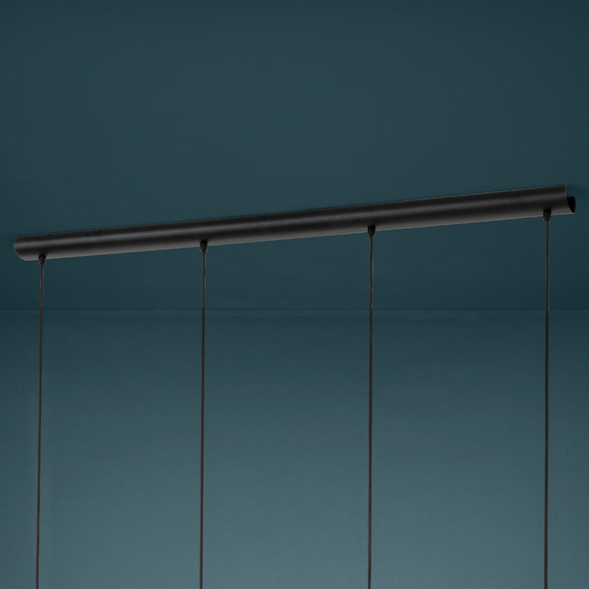 Black metal bar with three hanging black cords against a dark teal background.