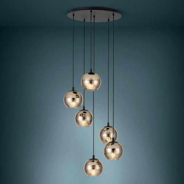 Six pendant lights with round, reflective gold-toned glass shades hang from a black ceiling plate.