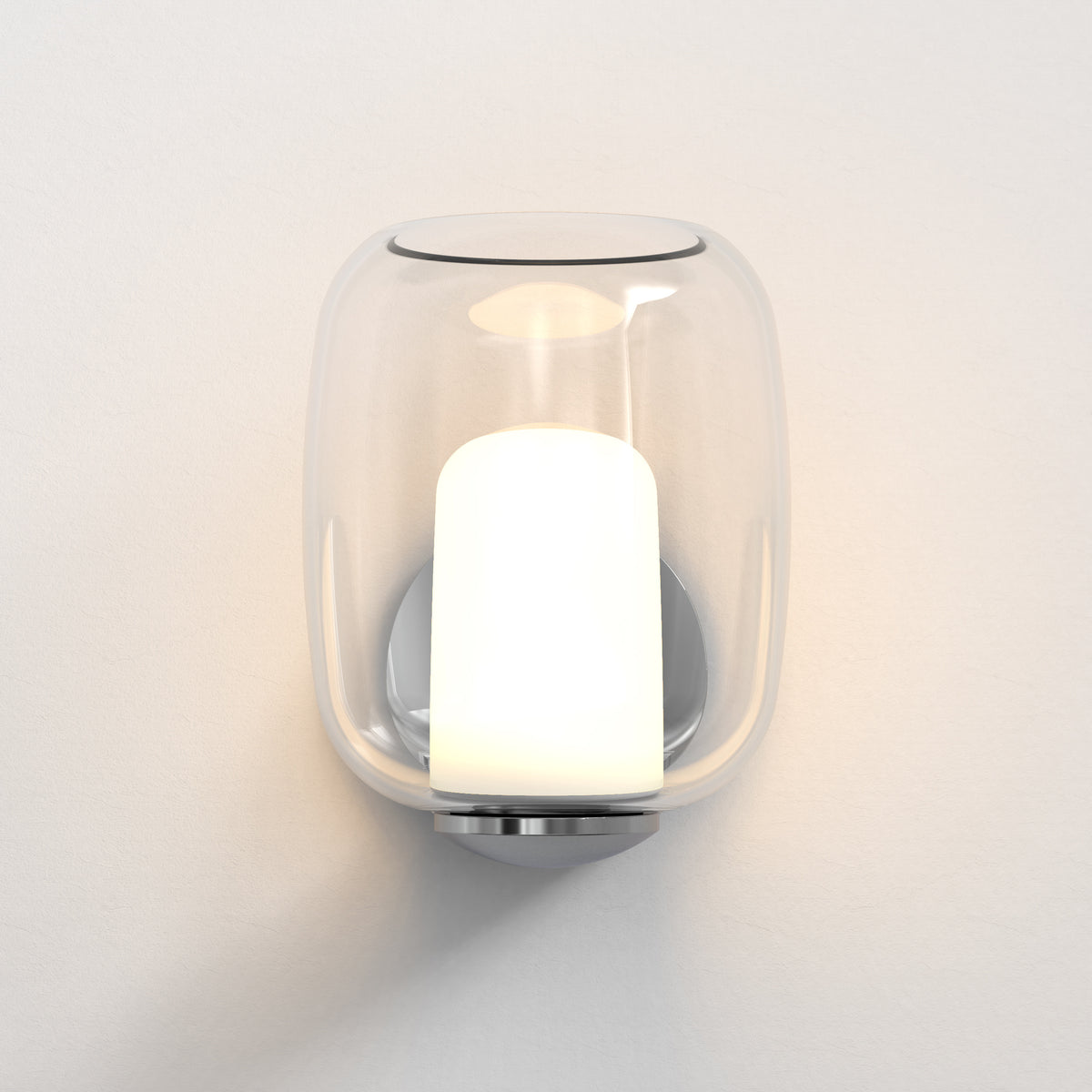 Modern wall sconce with a clear glass shade and an illuminated white cylindrical bulb