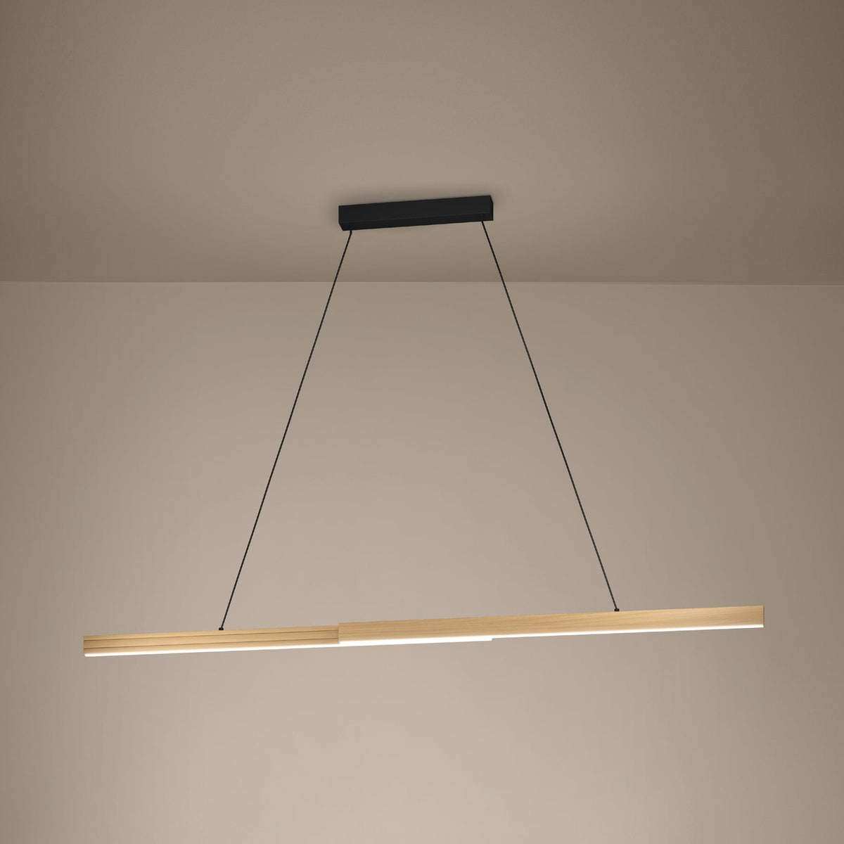 Linear wooden pendant light with a black ceiling mount and thin suspension wires