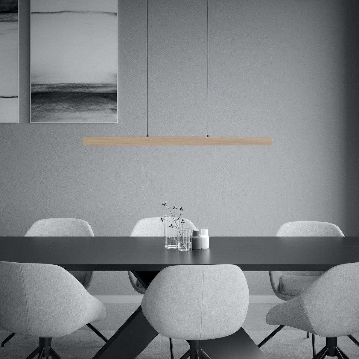 Dining room with a long black table, light grey chairs, and a wooden linear pendant light