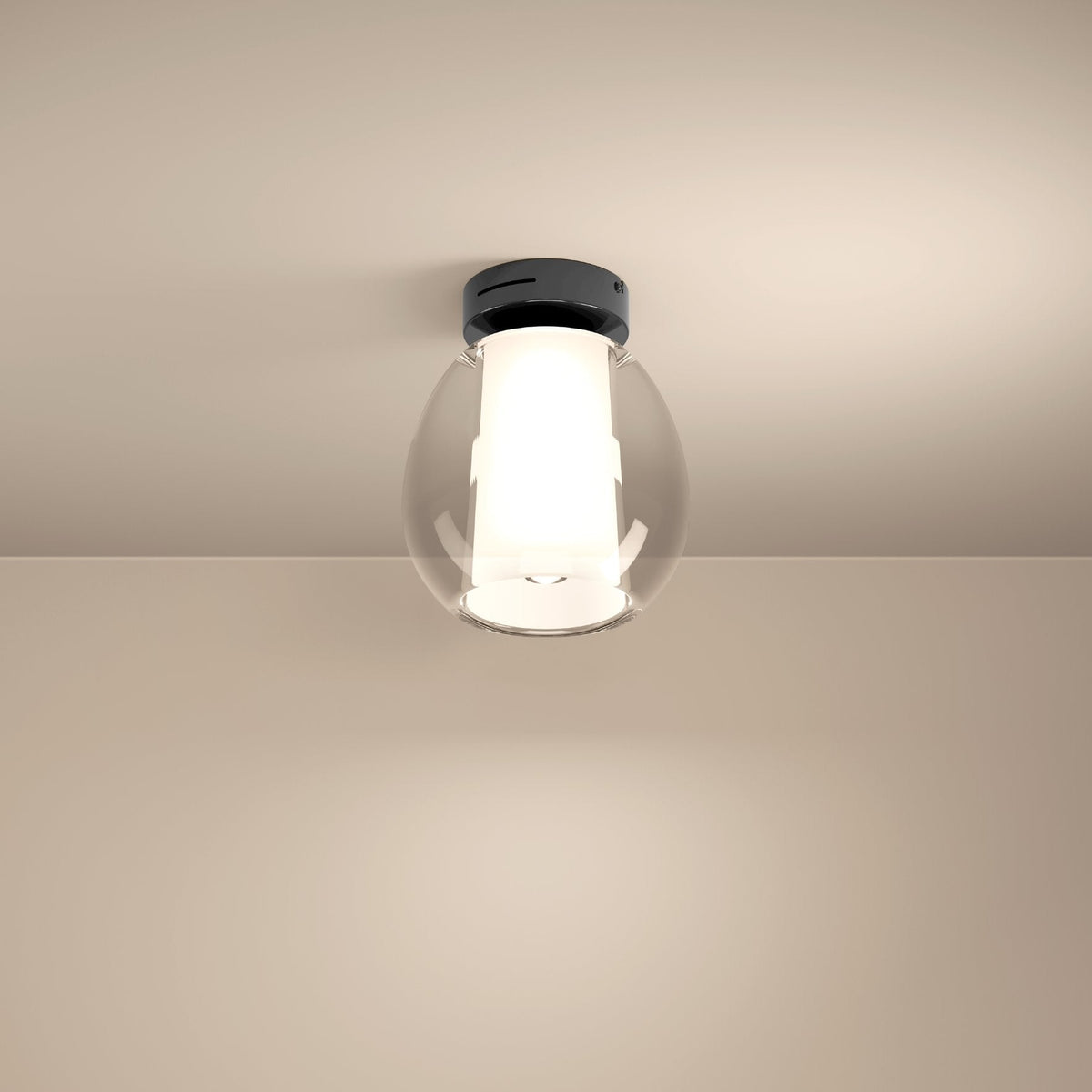 Ceiling light with a black base and a clear glass shade, illuminating a beige wall