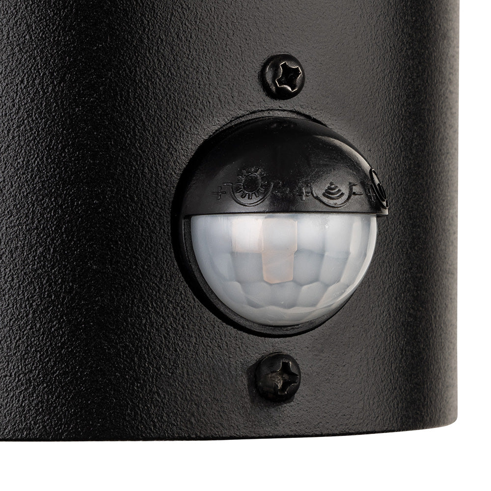 Close up of a black motion sensor with a clear dome and two screws