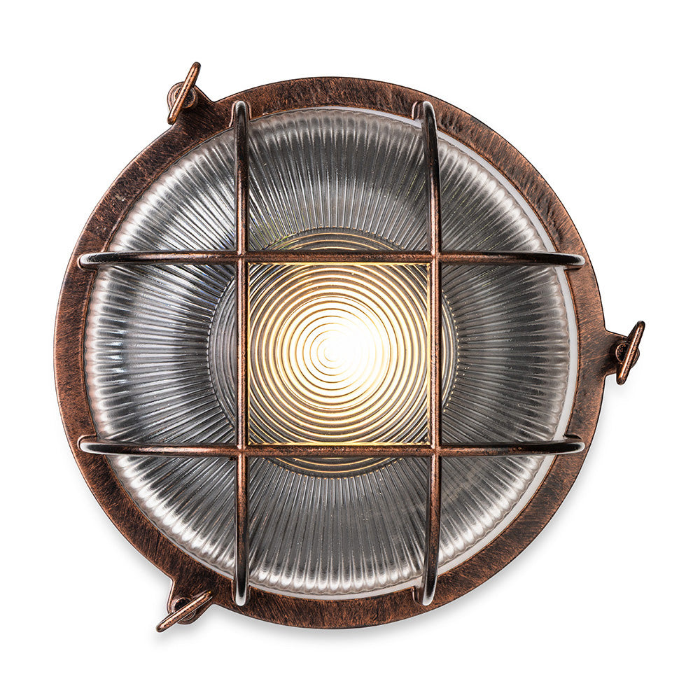Round copper-colored outdoor light with a clear glass shade and a metal cage over the bulb