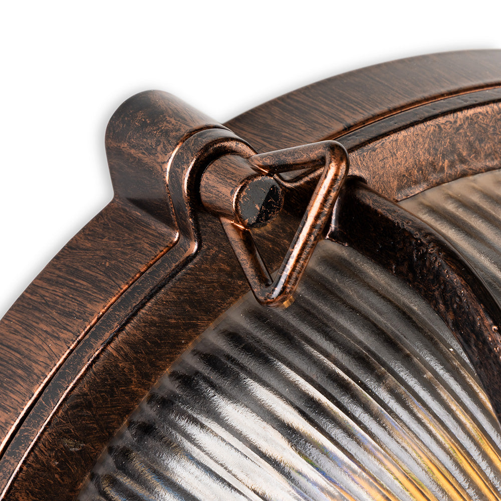 Close up of a bronze outdoor light fixture with a ribbed glass cover