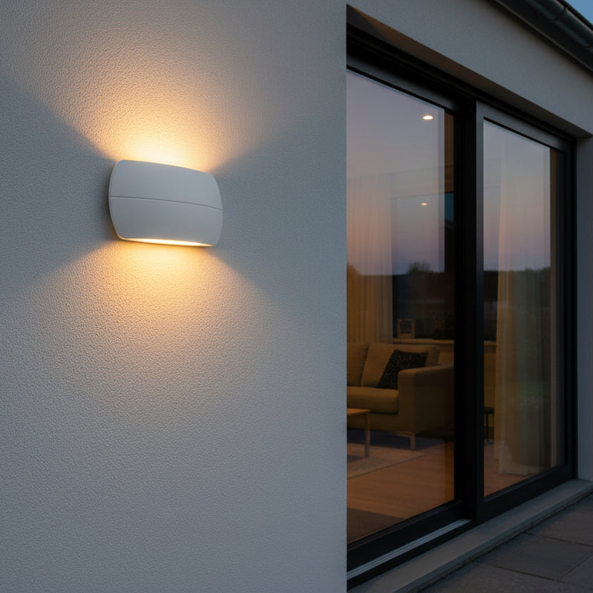 White outdoor wall light illuminating a textured wall next to a large glass door