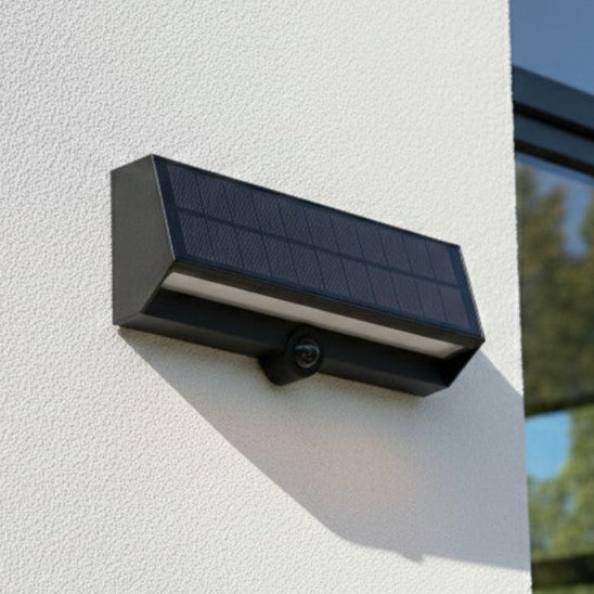 Solar powered security camera with integrated light mounted on a white wall