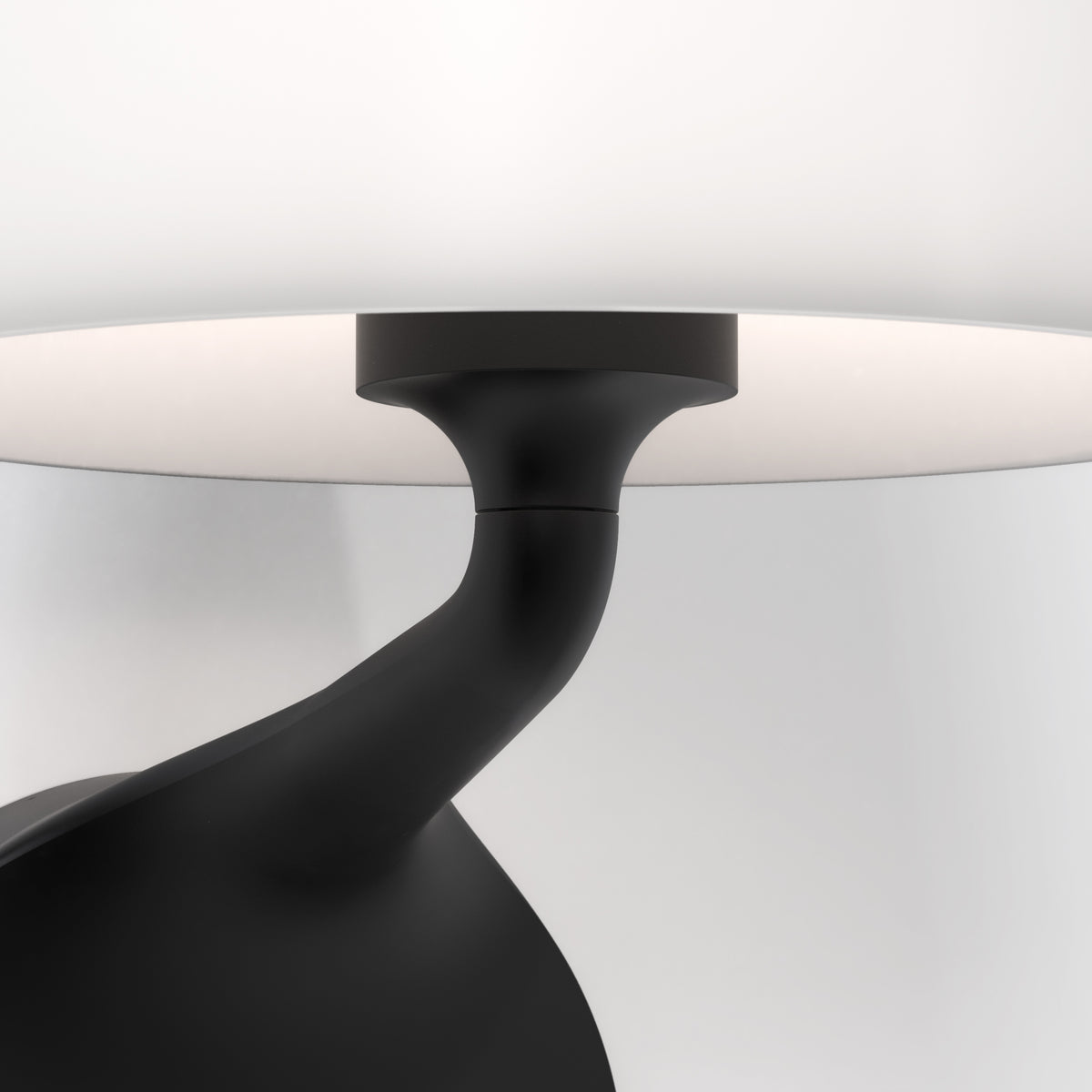 Close up of a black lamp base and stem with a white lampshade