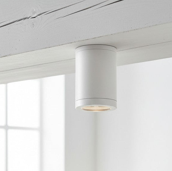 White cylindrical ceiling light fixture mounted on a white wooden beam
