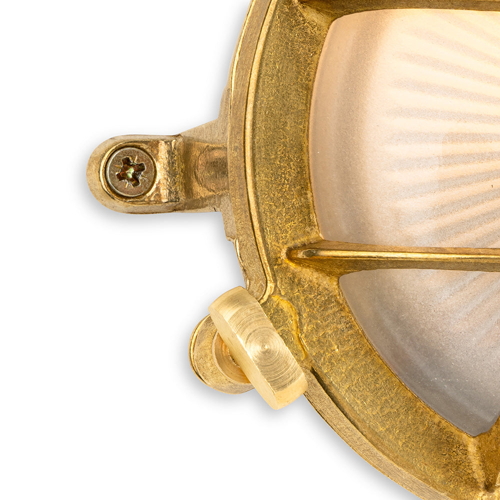 Close up of a brass bulkhead light with a frosted glass diffuser
