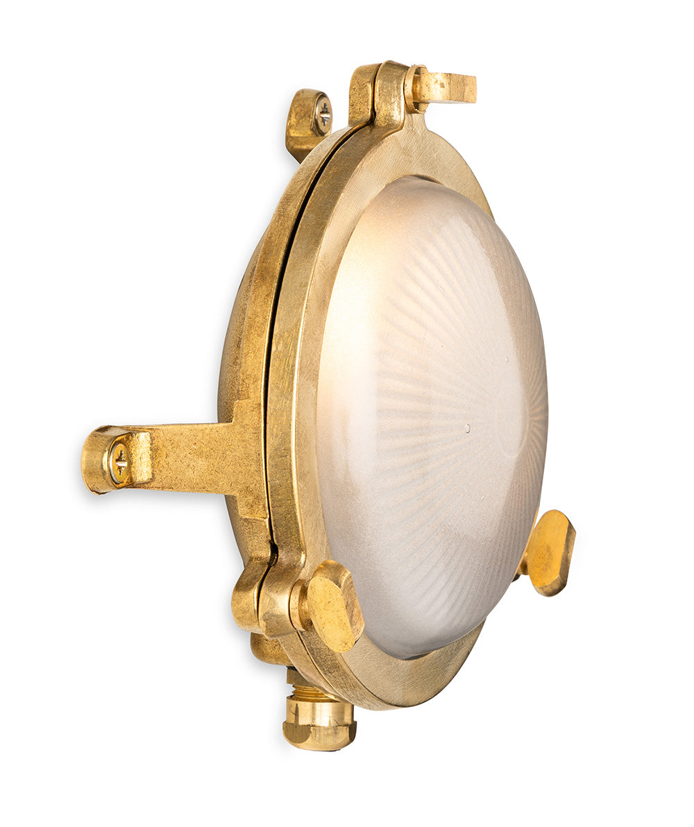 Round brass nautical wall light with a frosted glass dome
