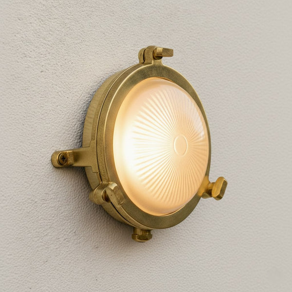 Round brass bulkhead light with a frosted glass diffuser