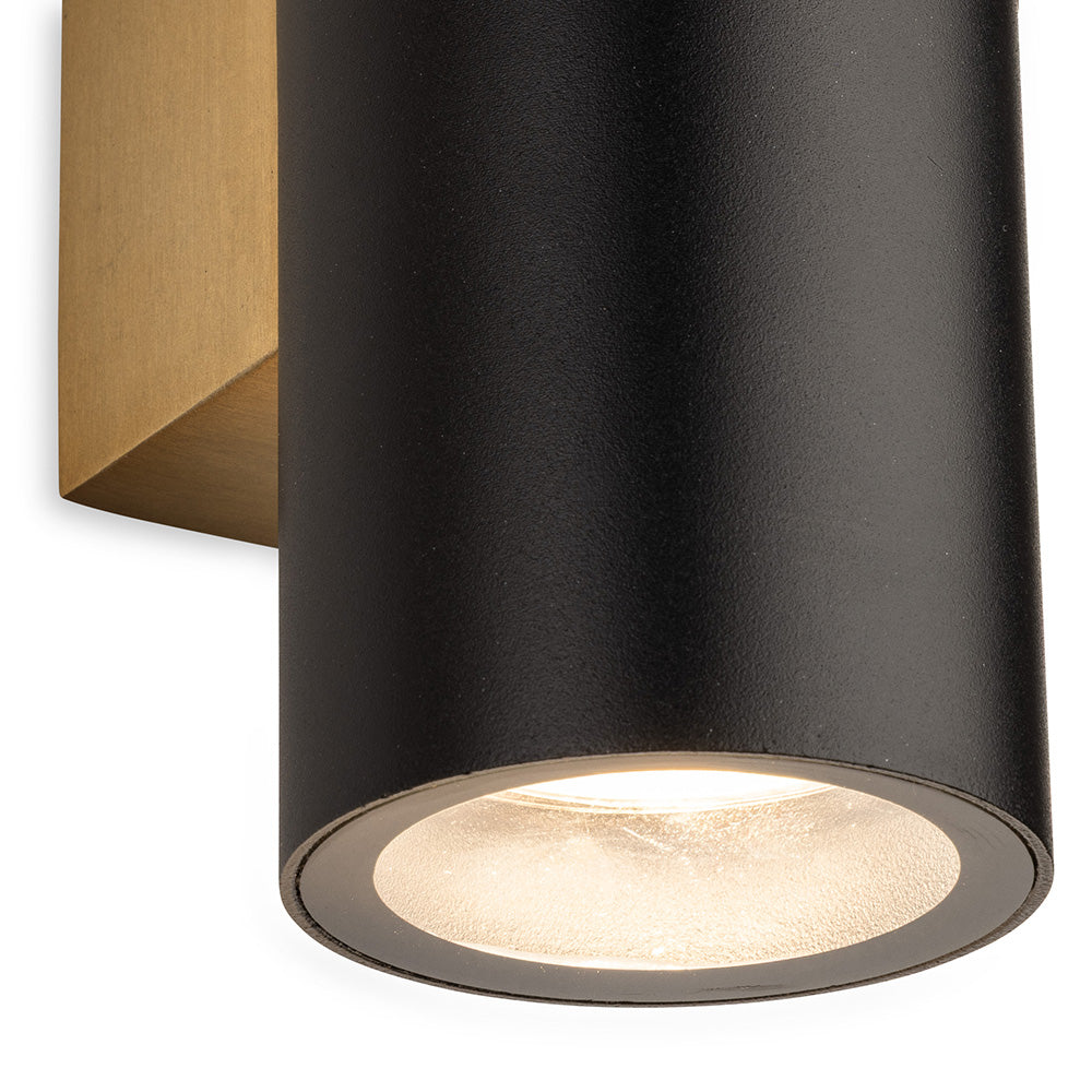 Black cylindrical wall light with a gold base