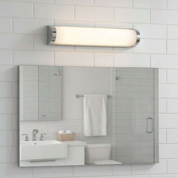 Bathroom with white subway tile, chrome light fixture, large mirror, white vanity, and toilet