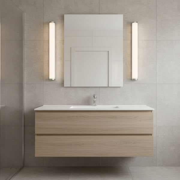 Bathroom vanity with light wood finish, white countertop, and rectangular mirror with two vertical lights