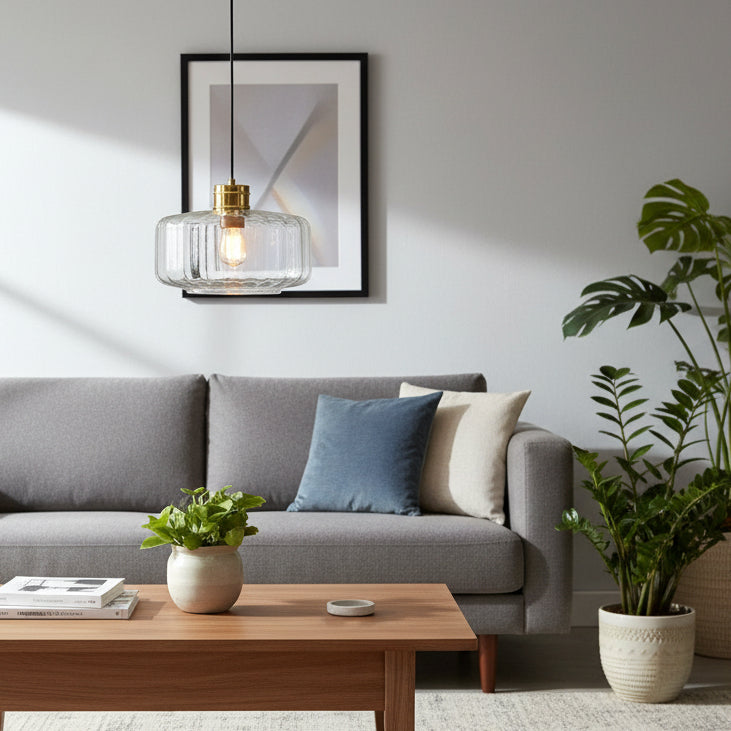 A living room with a grey sofa, wooden coffee table, and a glass pendant light