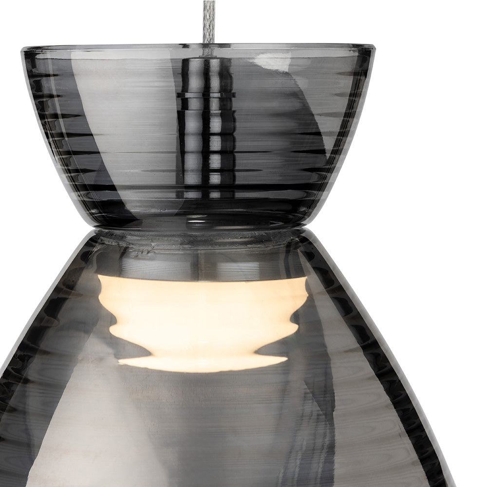 Close up of a grey glass pendant light with a lit bulb inside