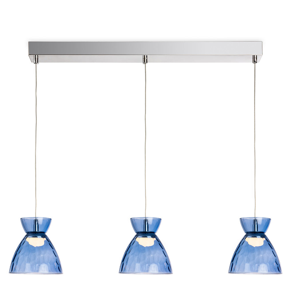 Three blue glass pendant lights with textured shades hang from a chrome bar