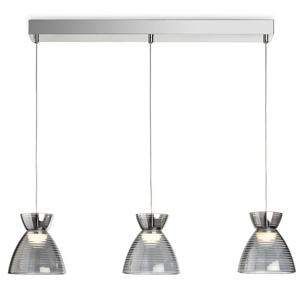 Three pendant lights with ribbed glass shades hanging from a chrome bar