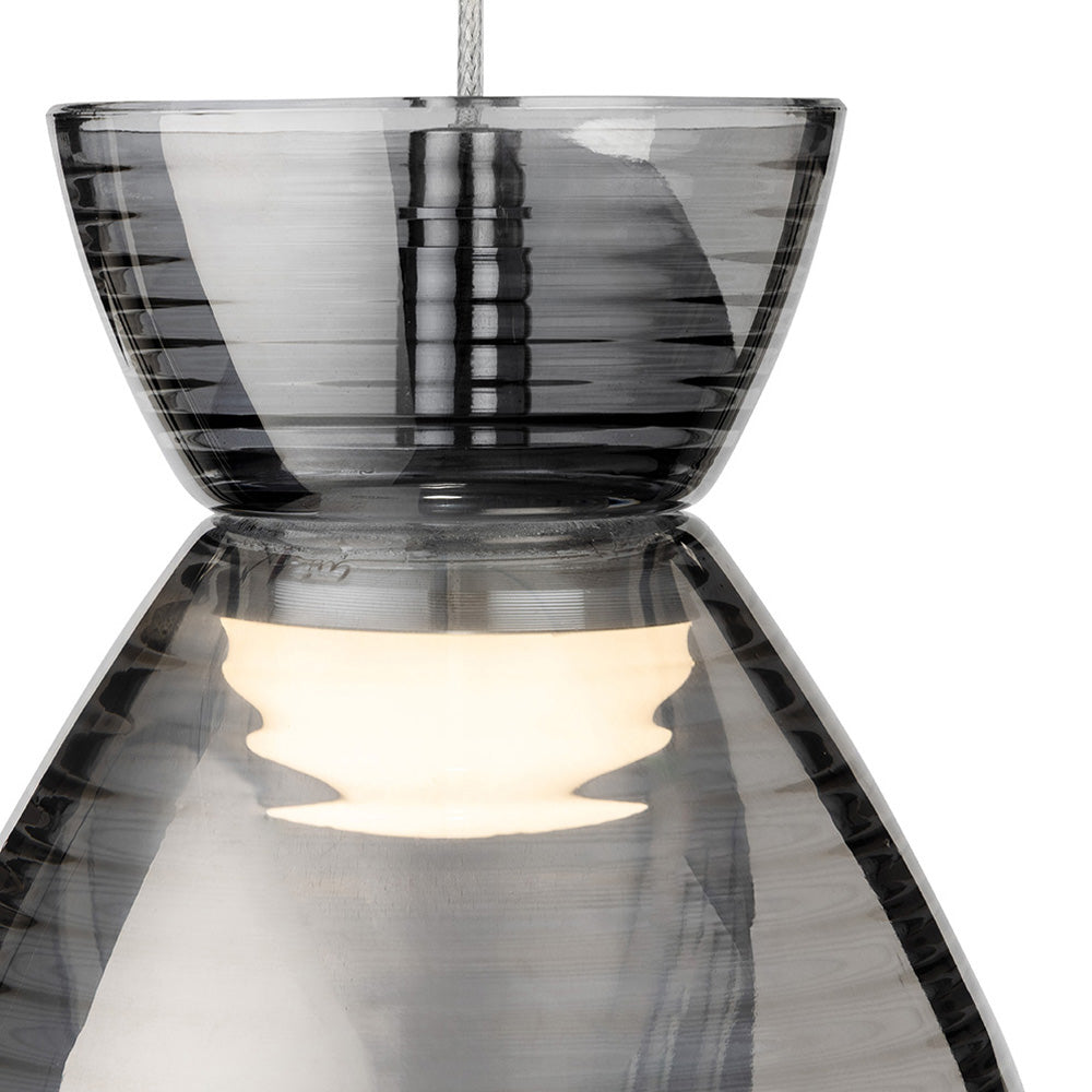Close up of a grey glass pendant light with a lit bulb inside