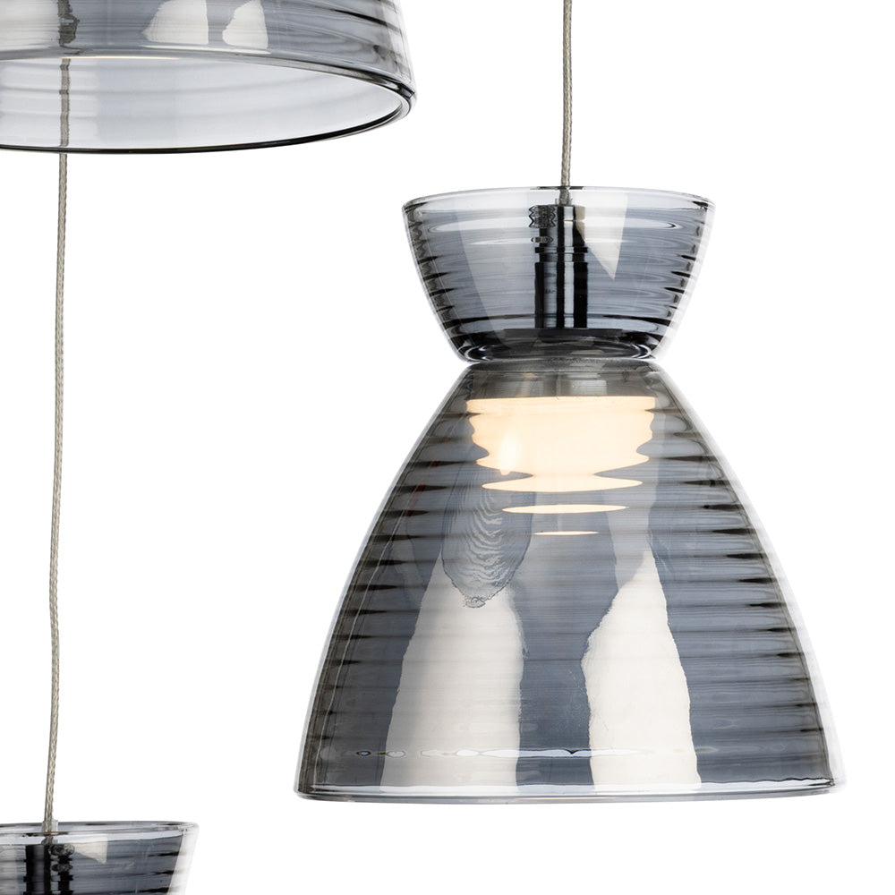Two grey glass pendant lights with horizontal ridges, one illuminated