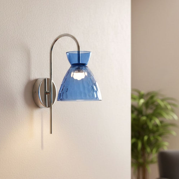 Blue glass wall sconce with a chrome finish on a light-colored wall