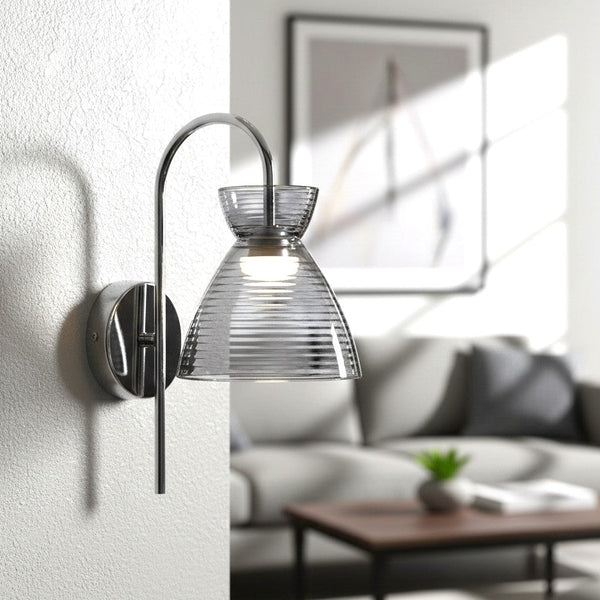 Chrome wall sconce with a ribbed glass shade in a living room