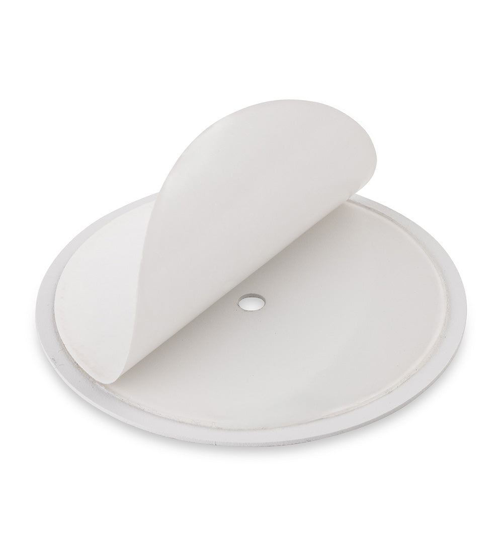 Round white adhesive patch with a small hole in the center, partially peeled back to show the sticky underside