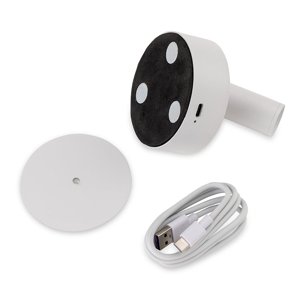 White mushroom-shaped device with black base and three white feet, a circular white stand, and a white USB cable