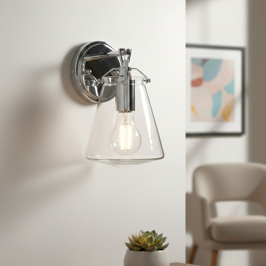 Chrome wall sconce with a clear glass conical shade and an exposed Edison bulb