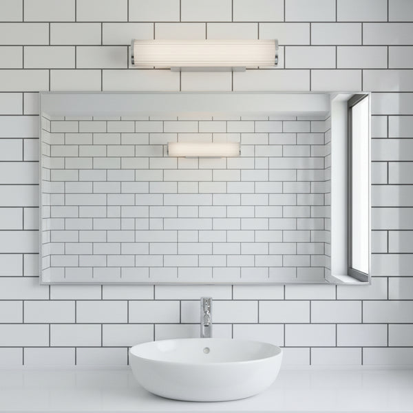 Bathroom with white subway tiles, a rectangular mirror, a white vessel sink, and two horizontal light fixtures