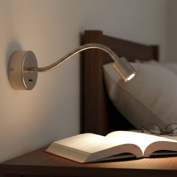 Adjustable wall-mounted reading light with a flexible arm illuminating an open book on a bedside table