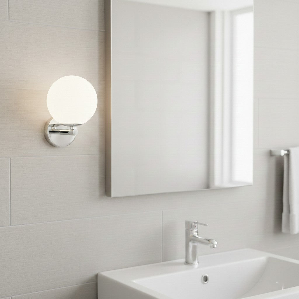 A bathroom with a white sink, a mirror, and a round wall light