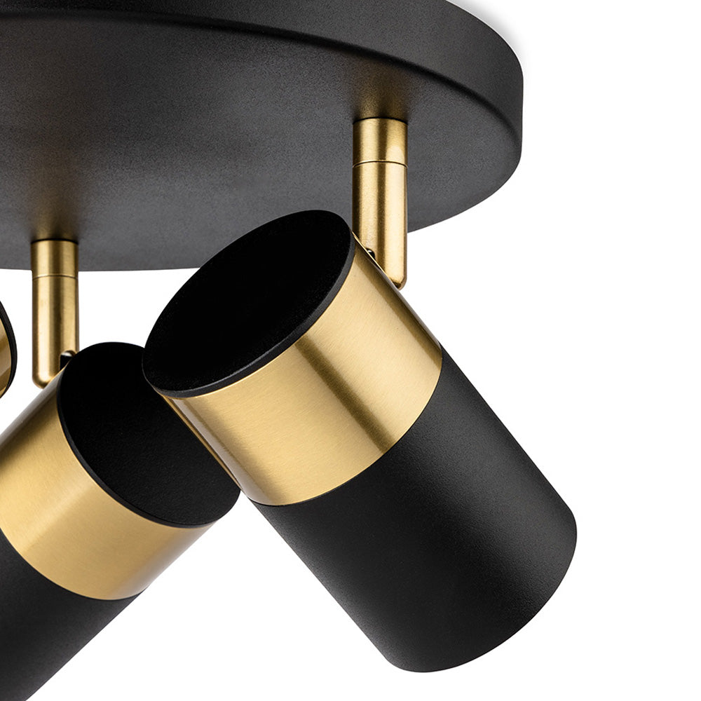 Close up of a black and gold ceiling light with three adjustable spotlights