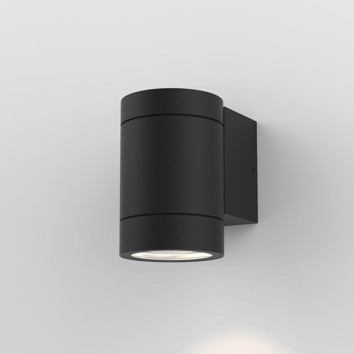 Black cylindrical outdoor wall light with two light sources, one facing up and one facing down