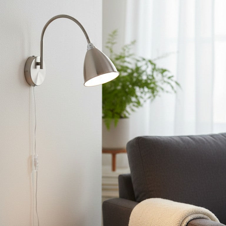 Brushed nickel wall lamp with a flexible arm and a conical shade, illuminating a living room