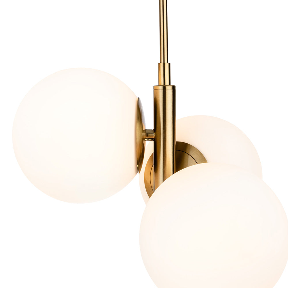 Close up of a brass chandelier with three white globe lights