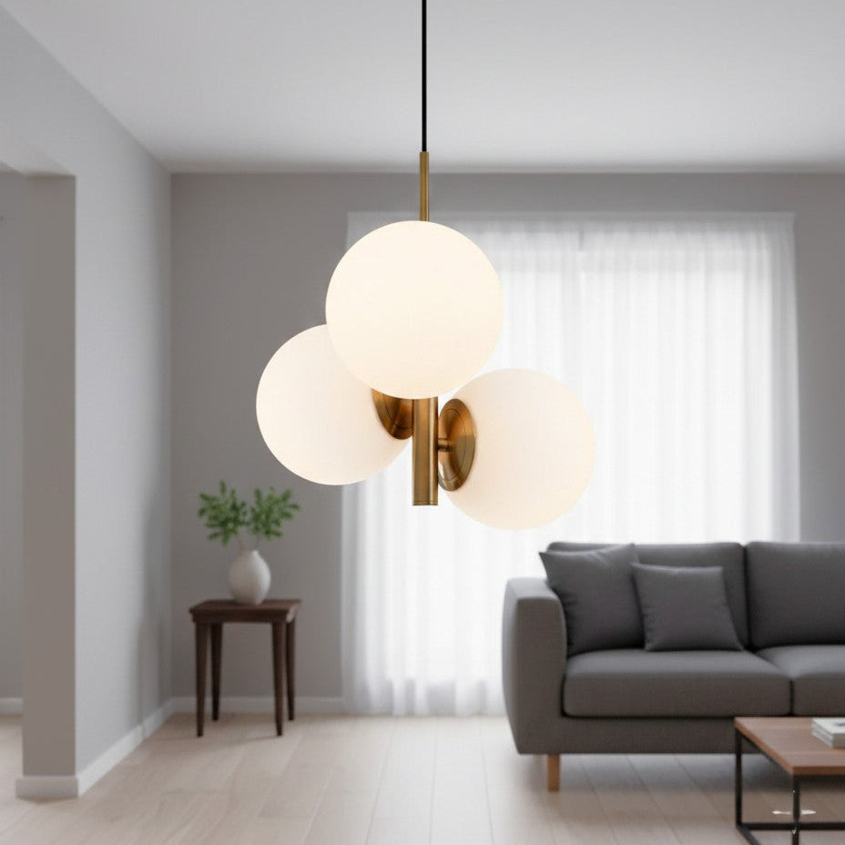 Three globe pendant light with brass accents in a living room