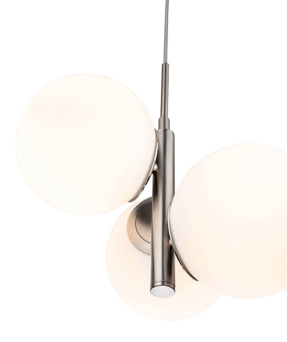 Close up of a modern pendant light with three white spherical shades and a brushed nickel finish
