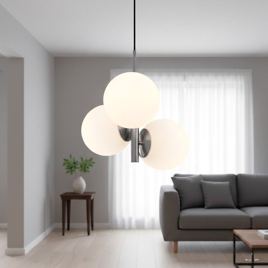 Three white globe pendant lights hanging from a ceiling in a living room