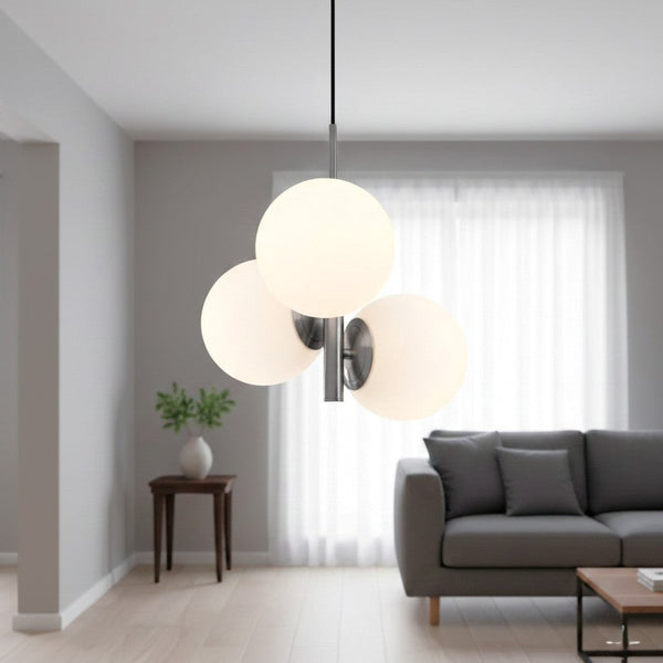 Three white globe pendant lights hanging from a ceiling in a living room