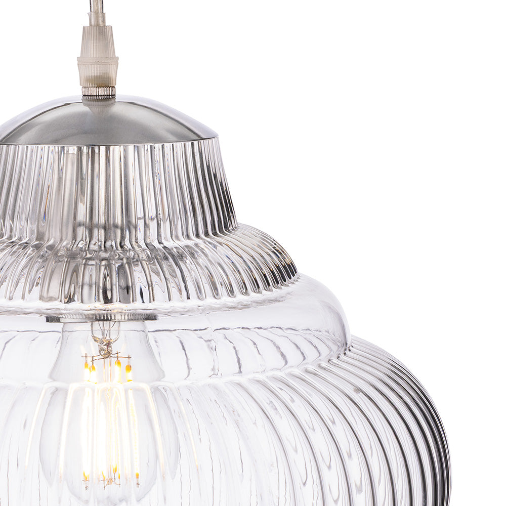 Close up of a clear glass pendant light with a ribbed texture and a silver top