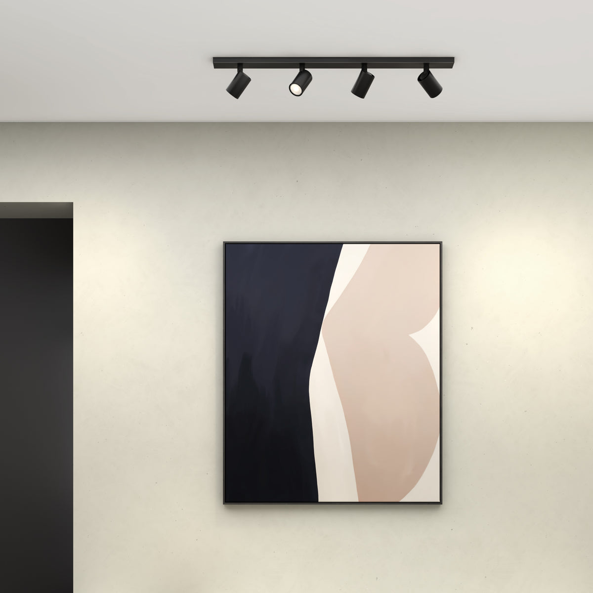 Black track lighting with four spotlights on a white ceiling above a framed abstract painting