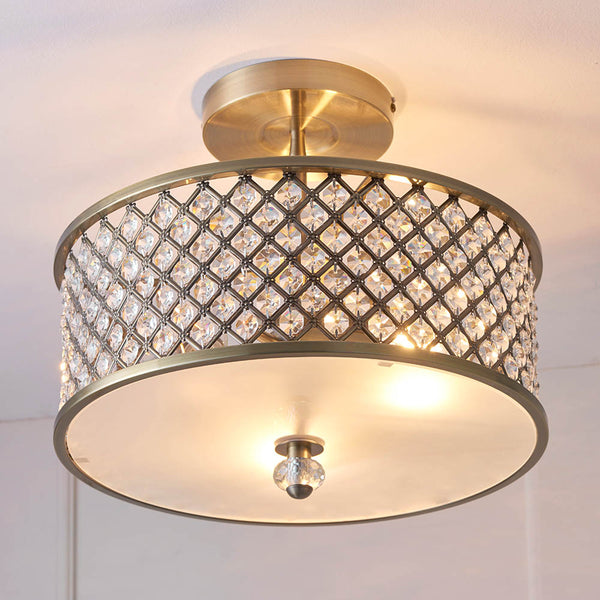 A gold semi-flush ceiling light with a crystal-encrusted drum shade illuminates a white ceiling.