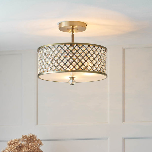 A close-up of a gold semi-flush ceiling light with a crystal-encrusted drum shade.