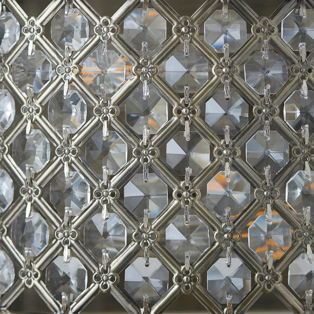 Detailed close-up of the unlit crystal grid pattern on an antique brass wall light.