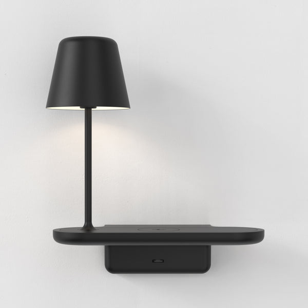 Black wall-mounted shelf with an integrated lamp and wireless charging pad